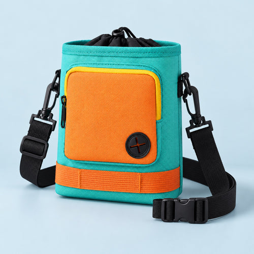 Teal and orange crossbody dog treat pouch on a mist-blue background