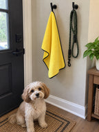 The pet towel hanging from its loop by the door next to a leash