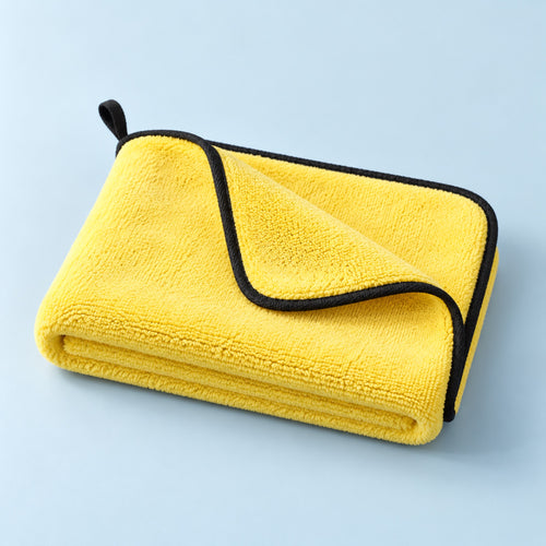 Folded yellow absorbent pet towel on a mist-blue background